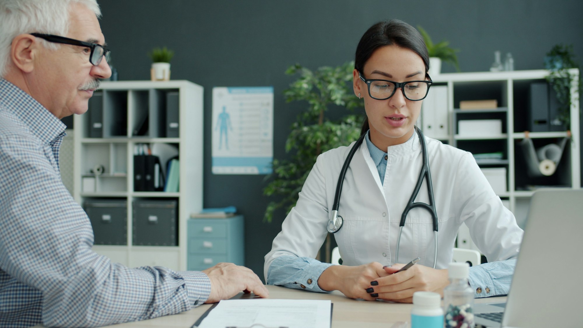 A podiatrist listening to an older patient